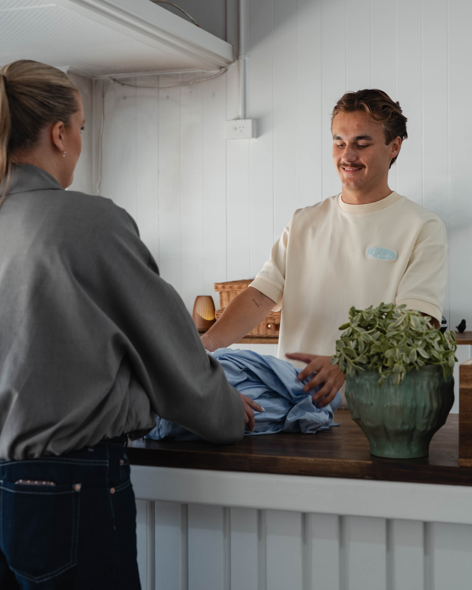A Kim’s team member serving a customer at the shop counter